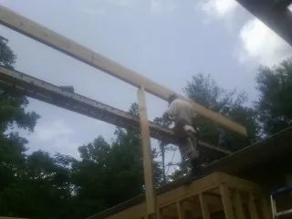 Carpenter setting a ridge beam over a new addition frame — Ice Dam Removal by Roofing Brothers in Mabel