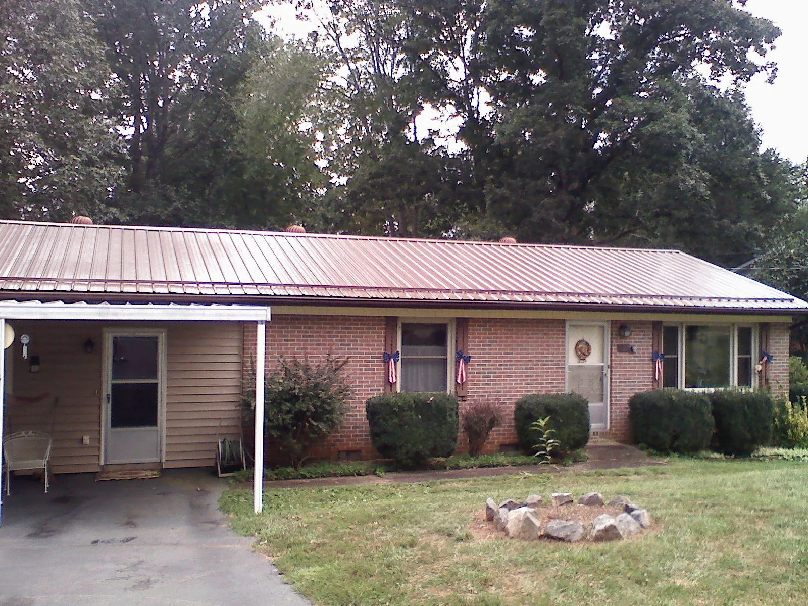 Bronze metal roof and carport on a brick ranch home — Roof Repair work by our crew in Mabel
